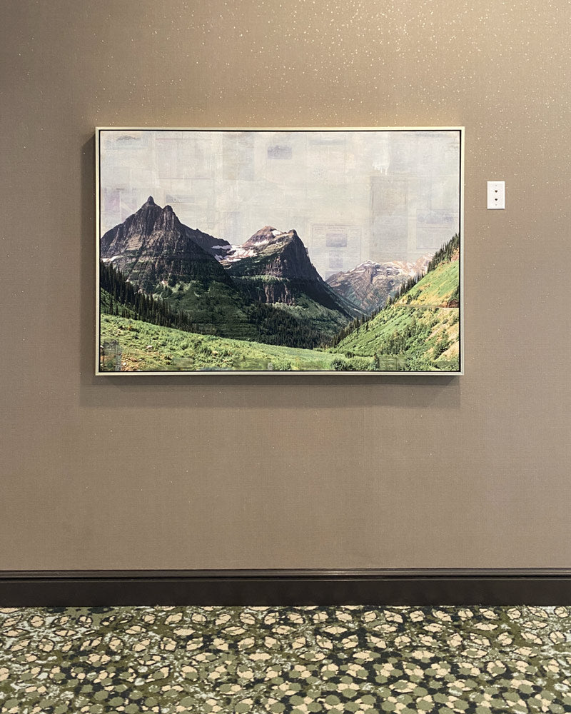 A mixed media piece with grey skies, stark mountains, and green grassy slopes in the foreground. The view is from Logan Pass looking towards Going to the Sun Mountain.
